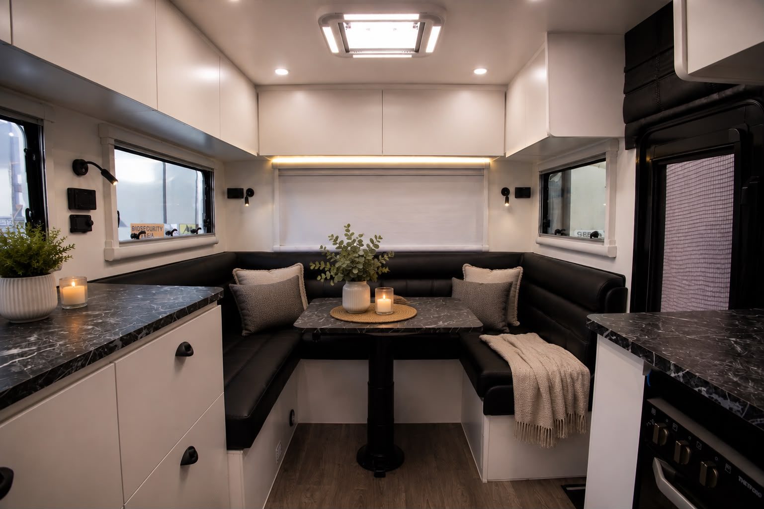 U-shaped club lounge in black leather around a round timber dinette table