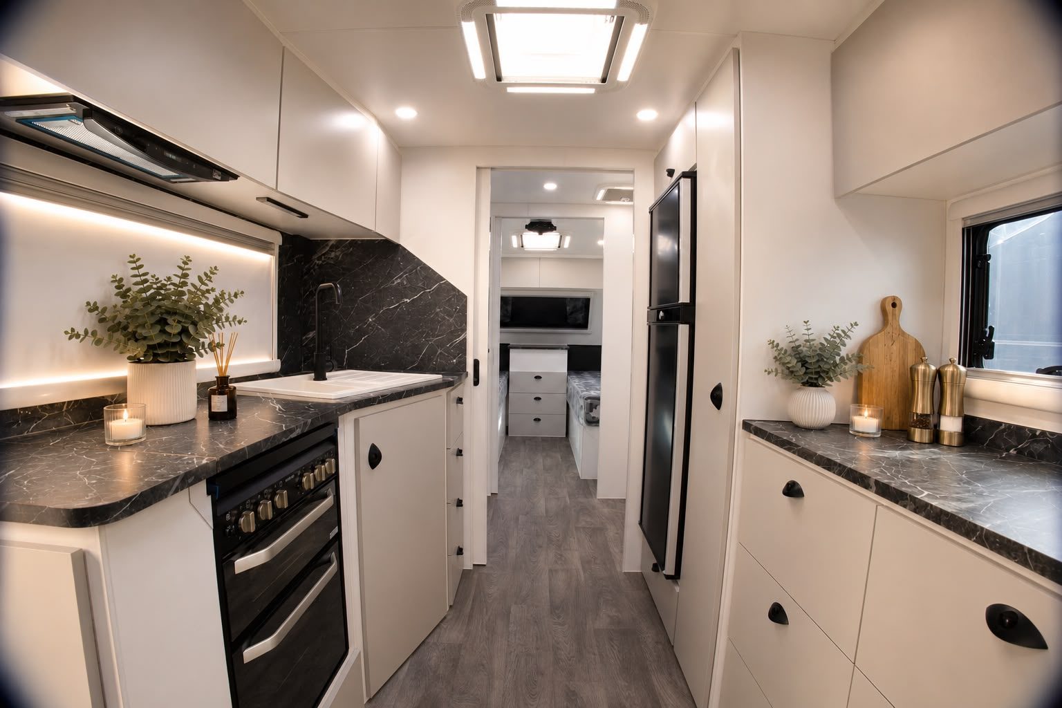 Galley kitchen with stone splashback and oven, looking through to the bedroom
